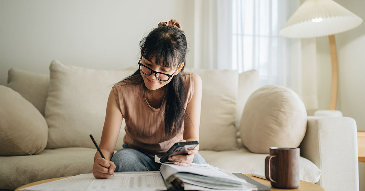 Personne qui calcule comment faire un budget et qui écrit dans un cahier