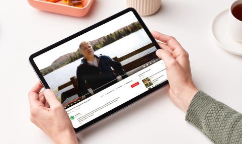 Sur une tablette, on aperçoit un homme devant un lac qui s’exprime dans une vidéo.